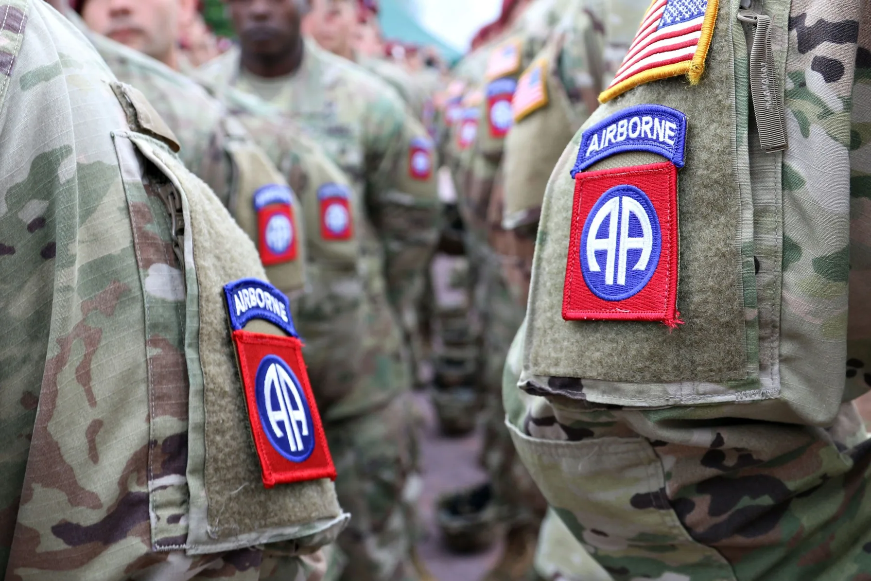 U.S. Army soldiers wearing 82nd Airborne Division shoulder patches stand in formation ahead of a Middle East deployment